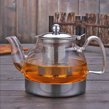 Borosilicate glass teapot sitting on induction cooktop burner with infuser inside