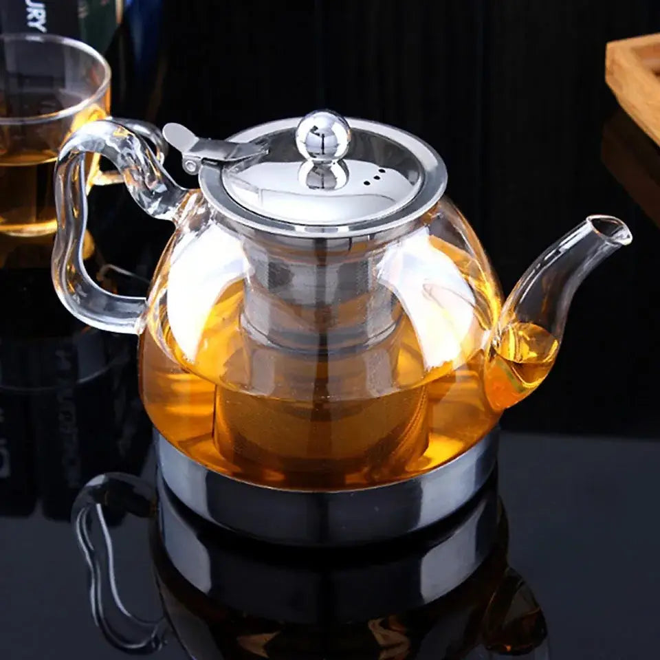 Clear glass teapot with loose leaf tea steeping, color visible through the glass walls