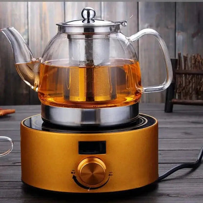 Glass teapot for loose leaf tea pouring a full cup of brewed tea