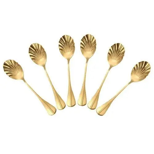 Set of six gold shell teaspoons arranged on a white tea tray