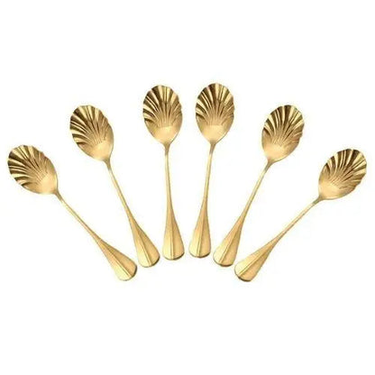 Set of six gold shell teaspoons arranged on a white tea tray