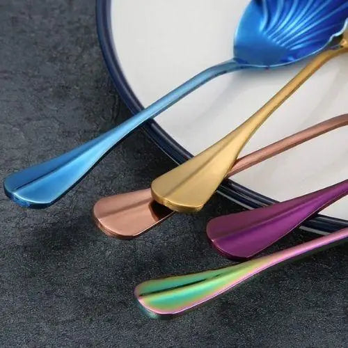 Six gold tea spoons fanned out showing uniform finish and size
