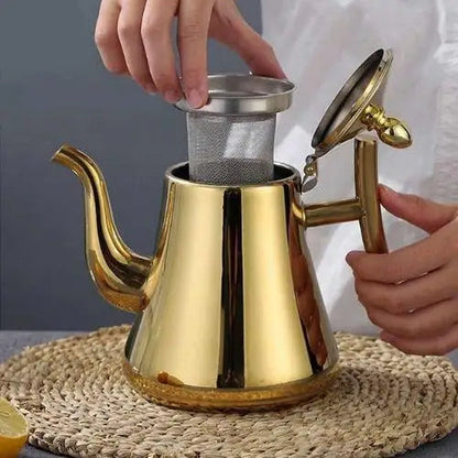 Gold stainless steel teapot with infuser displayed on kitchen table