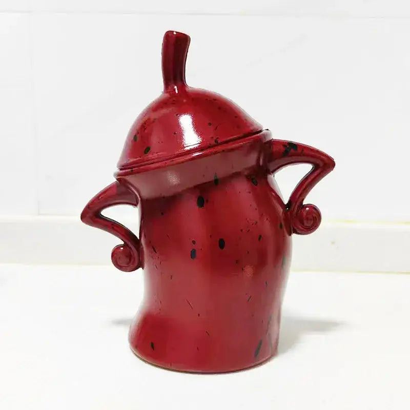 Red tea bag holder with hands-on-hips character, close-up detail