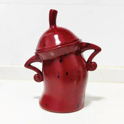 Red tea bag holder with hands-on-hips character, close-up detail