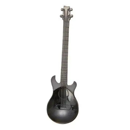 Black guitar tea spoon on wooden table