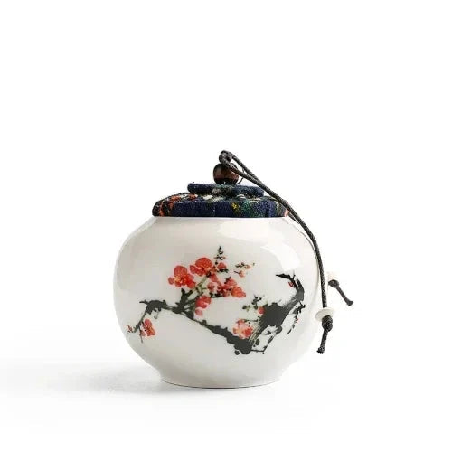 Hand-painted Chinese tea jar on kitchen shelf beside loose leaf tea