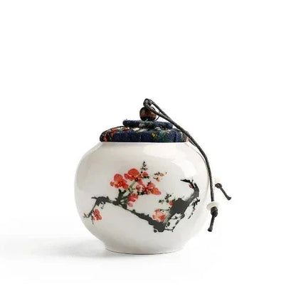 Hand-painted Chinese tea jar on kitchen shelf beside loose leaf tea
