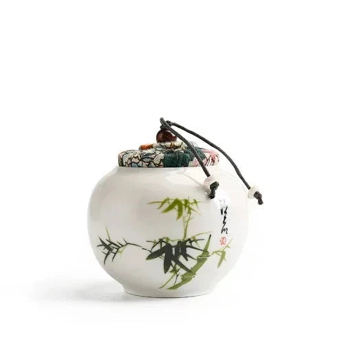 Ceramic tea canister plum blossom and bamboo motifs side by side