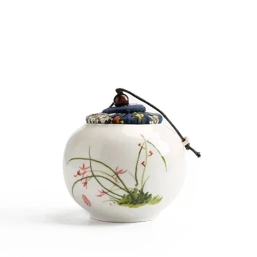 Small ceramic tea storage jar lid closed front view showing hand-painted detail