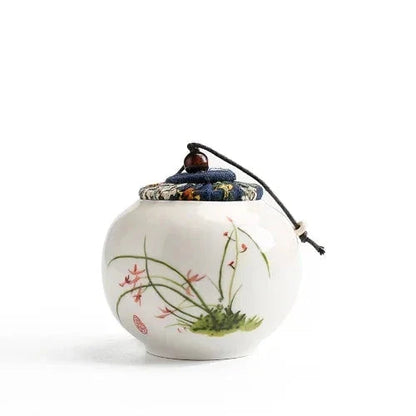 Small ceramic tea storage jar lid closed front view showing hand-painted detail