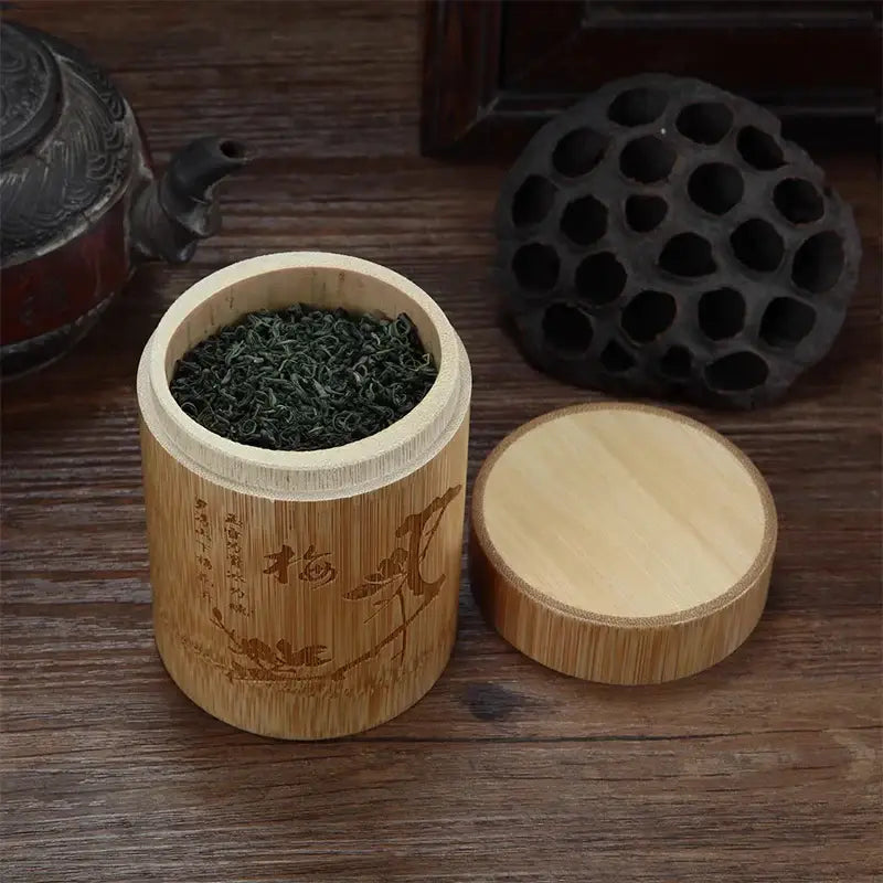Small bamboo tea canister with fitted lid on natural wood surface