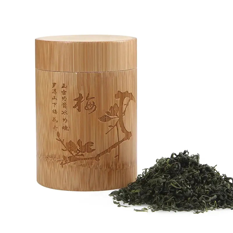 Bamboo tea storage canister on kitchen counter next to a tea cup