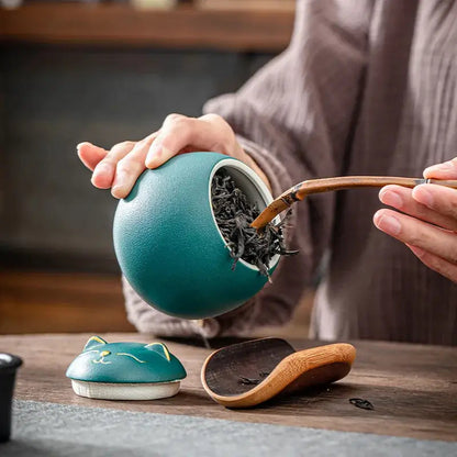 Ceramic cat tea canister open lid with loose-leaf tea inside
