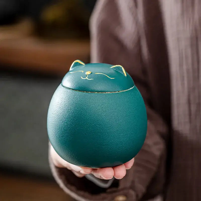 Orange hand-thrown ceramic cat canister on kitchen counter