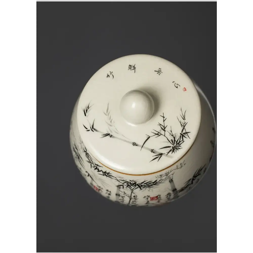Ceramic tea canister bamboo forest design shown open with loose leaf tea inside