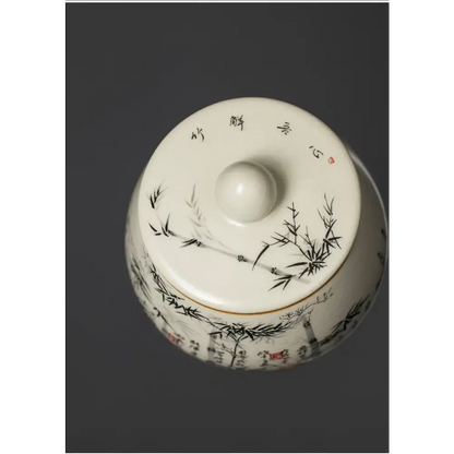 Ceramic tea canister bamboo forest design shown open with loose leaf tea inside