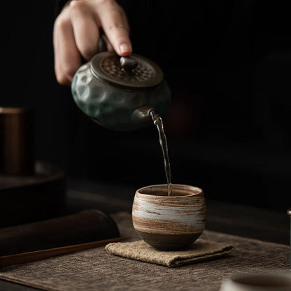 Japanese stoneware tea cup showing raw clay exterior and glazed interior