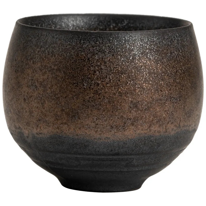 Handmade stoneware tea cup held in hand showing 210ml size and grip