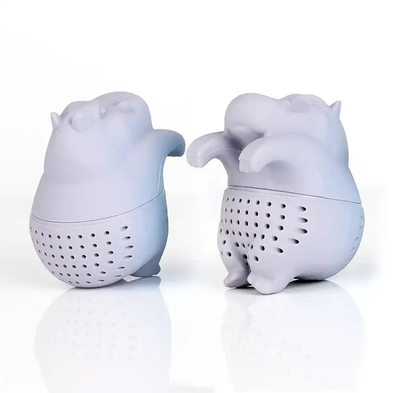 Hippo tea strainer with tea leaves next to it