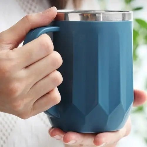 Person holding insulated tea mug