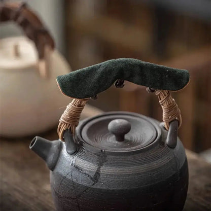 Insulated teapot handle cover in green on a teapot