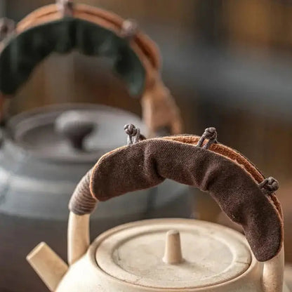 Teapot handle cover in coffee color on a teapot