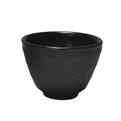 Traditional black iron teacup with steam rising from hot tea