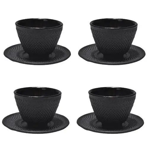 Four Japanese cast iron teacups with saucers arranged for tea ceremony