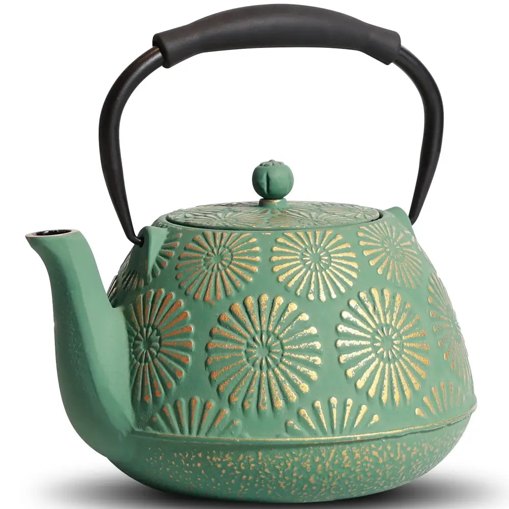 Green Japanese cast iron teapot with gold accents on a wooden table