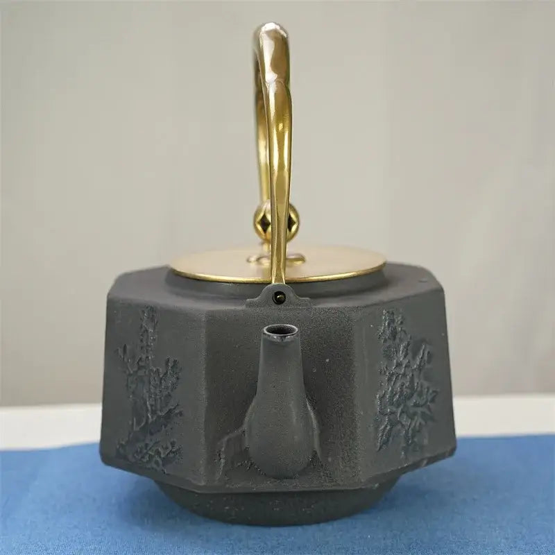 Handcrafted cast iron tetsubin teapot heating directly on gas stovetop