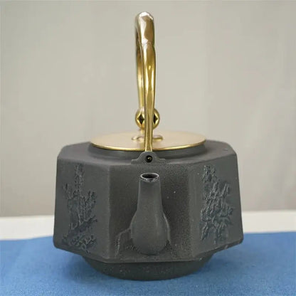 Handcrafted cast iron tetsubin teapot heating directly on gas stovetop