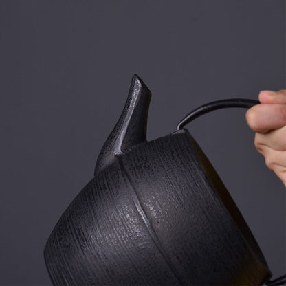 Black cast iron teapot with small Japanese tea cups, table setting