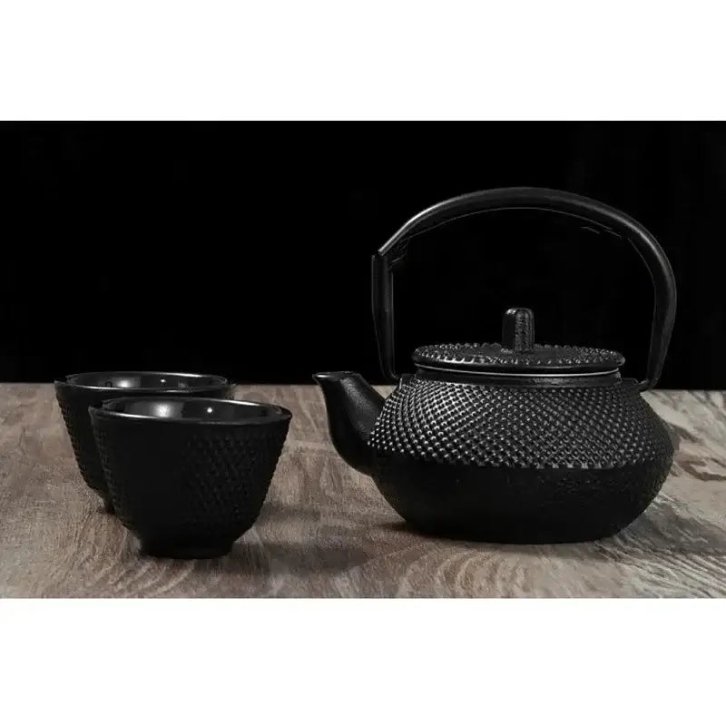 Cast iron teapot 300ml pouring hot tea into ceramic cup