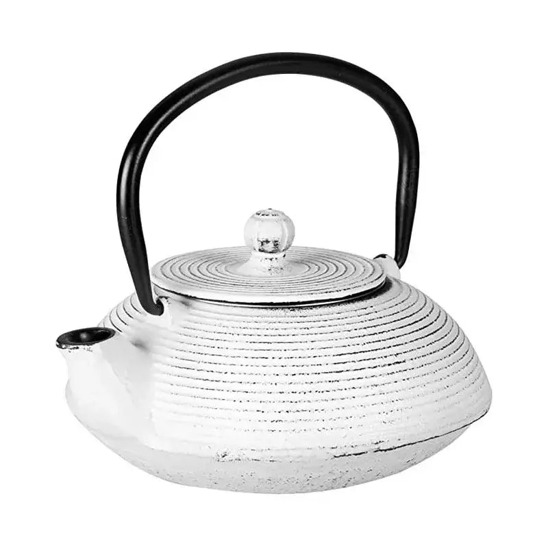 White cast iron teapot with lid on wooden table