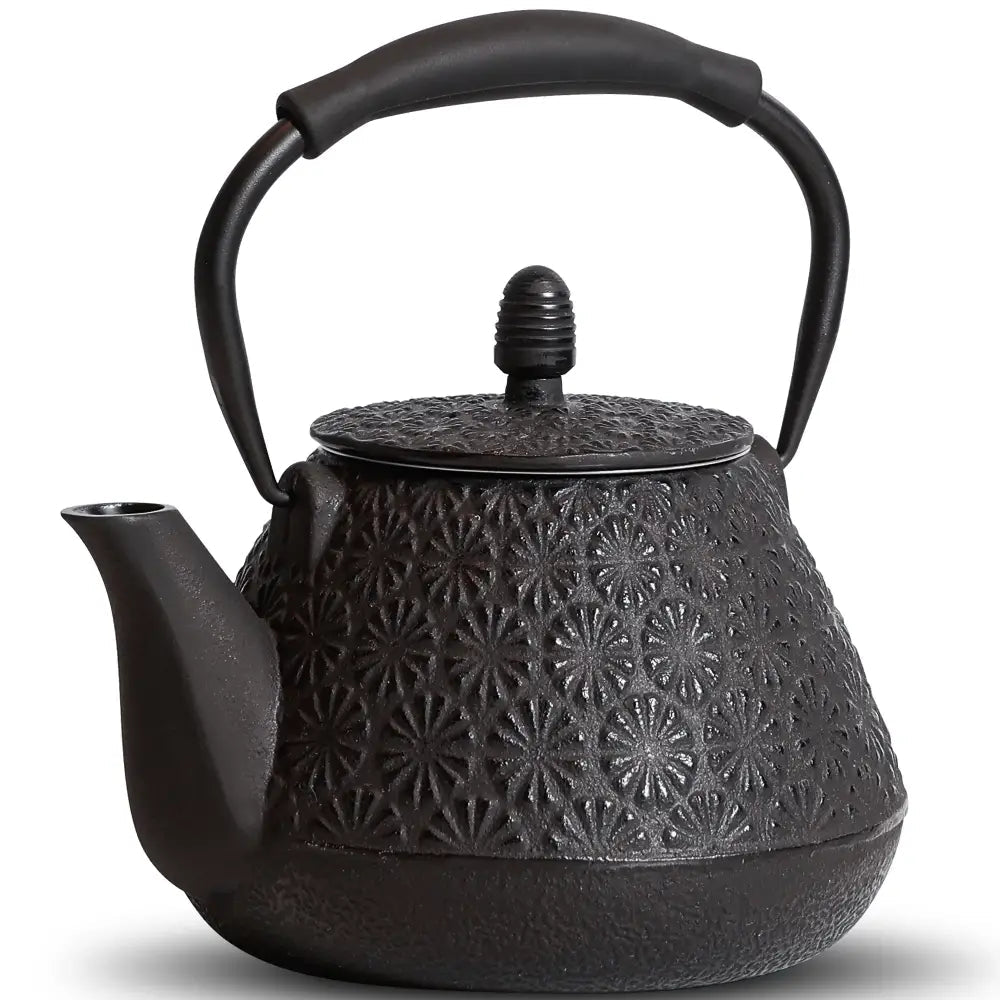 Black cast iron teapot with lid on wooden table