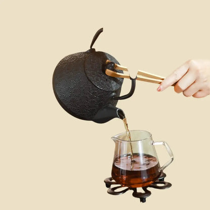 Cast iron teapot with steam rising from spout