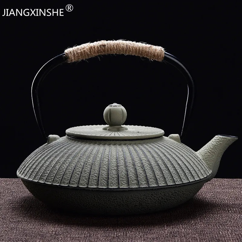 Flat tetsubin cast iron teapot detail showing hammered body and natural rope handle