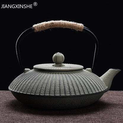 Flat tetsubin cast iron teapot detail showing hammered body and natural rope handle
