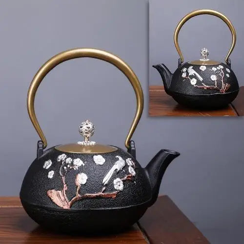 Black and gold cast iron teapot with floral pattern