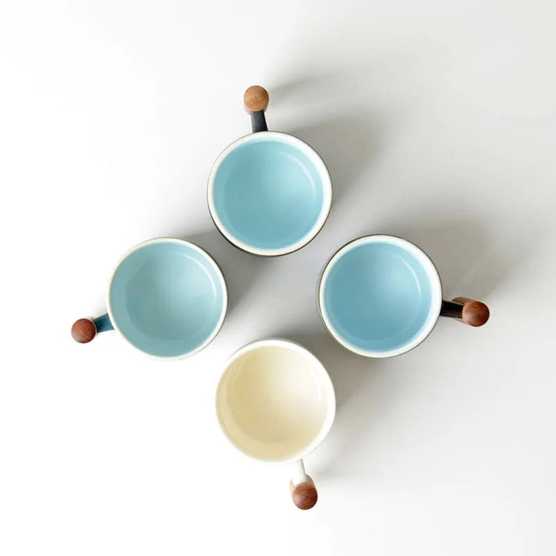 Navy blue Japanese ceramic tea cup with wooden handle resting on a ceramic saucer
