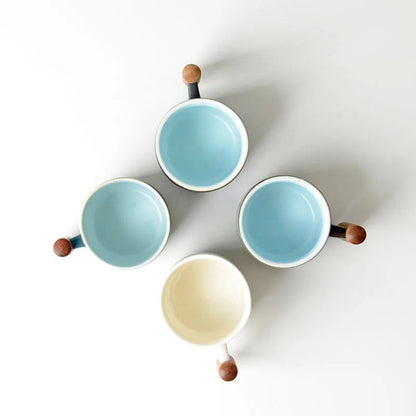Navy blue Japanese ceramic tea cup with wooden handle resting on a ceramic saucer