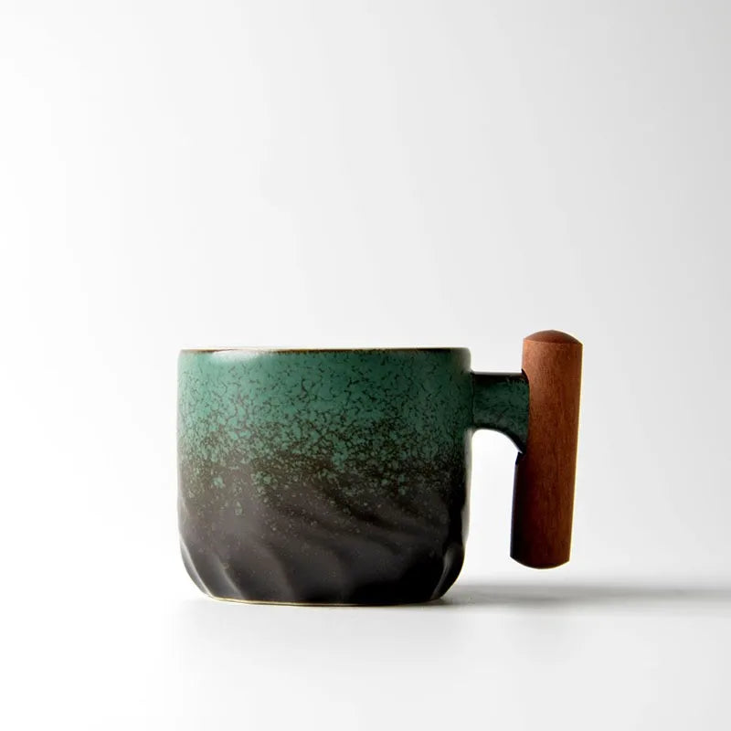Black ceramic tea cup with wooden handle placed on a dark wood serving tray