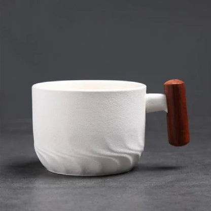 Hand holding Japanese ceramic tea cup by its natural wood handle showing grip comfort