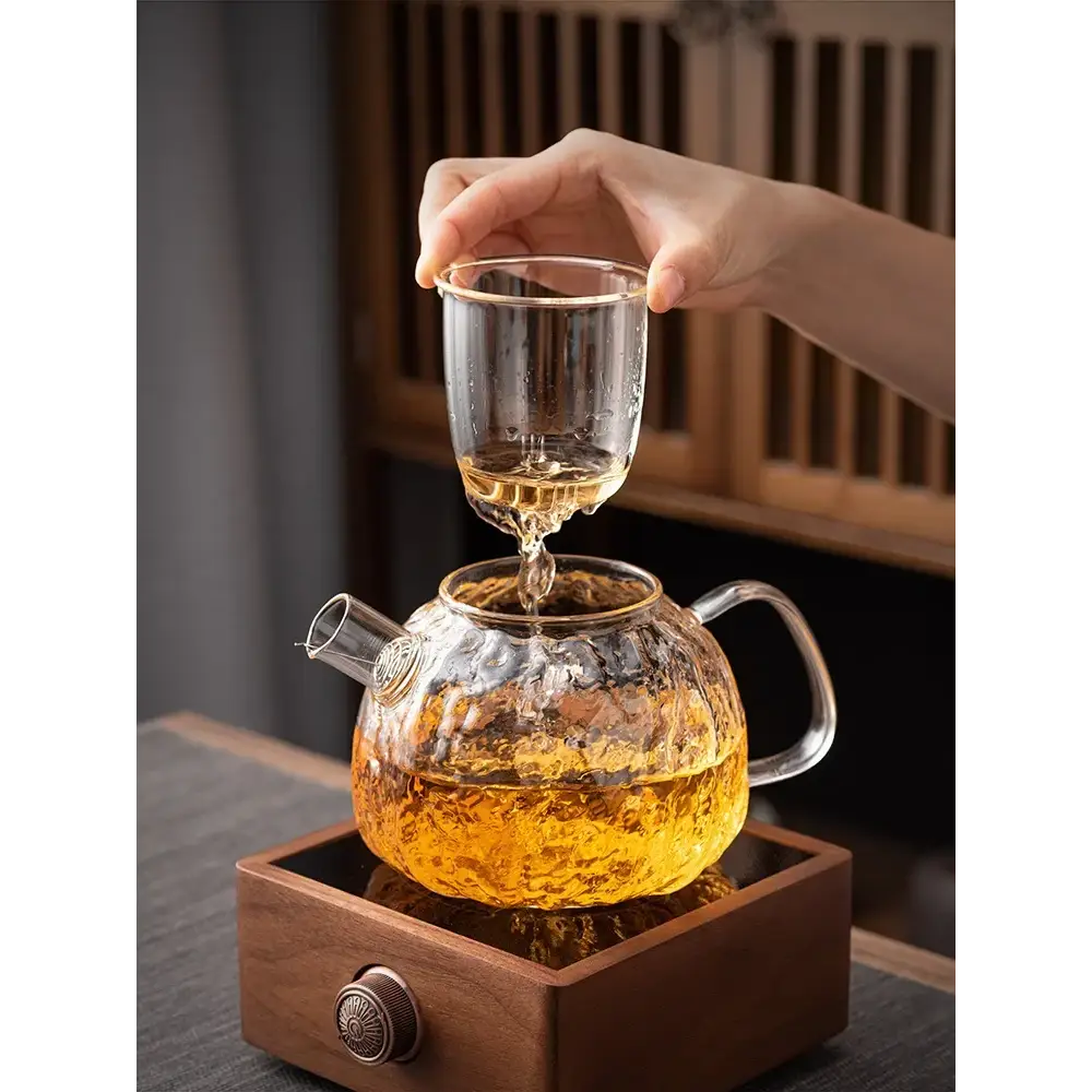 Glass teapot brewing loose leaf tea showing amber steep color