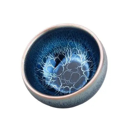 Tenmoku matcha bowl with oil-spot glaze pattern, blue tones from high-fire iron oxide