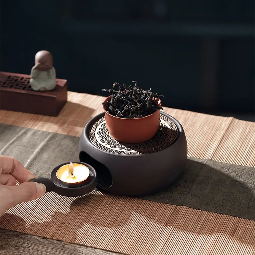 Japanese tea warmer sculpted grid holding ceramic teapot from above