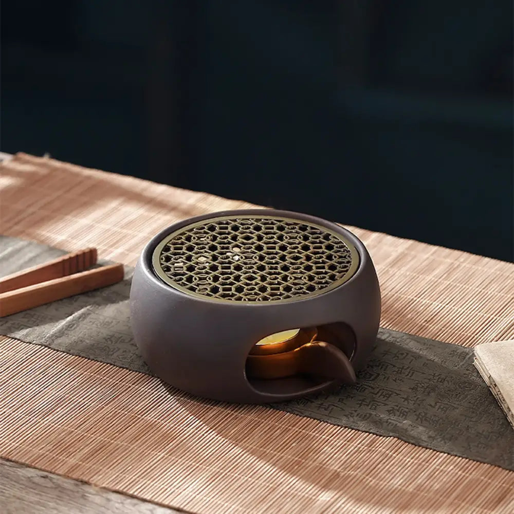 Sculpted grid candle tea warmer for teapots displayed on kitchen counter