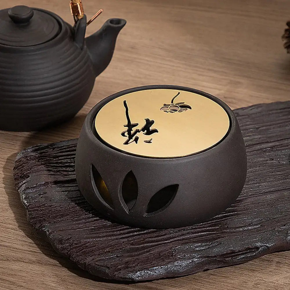 Japanese ceramic teapot warmer with lit candle keeping teapot warm from below