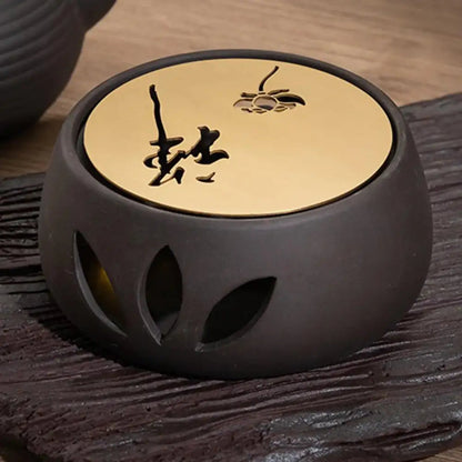 Ceramic candle teapot warmer holding a glass teapot, side view